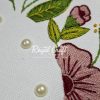 Macro shot of elegant floral embroidery featuring pink petals green leaves and applied pearl beads